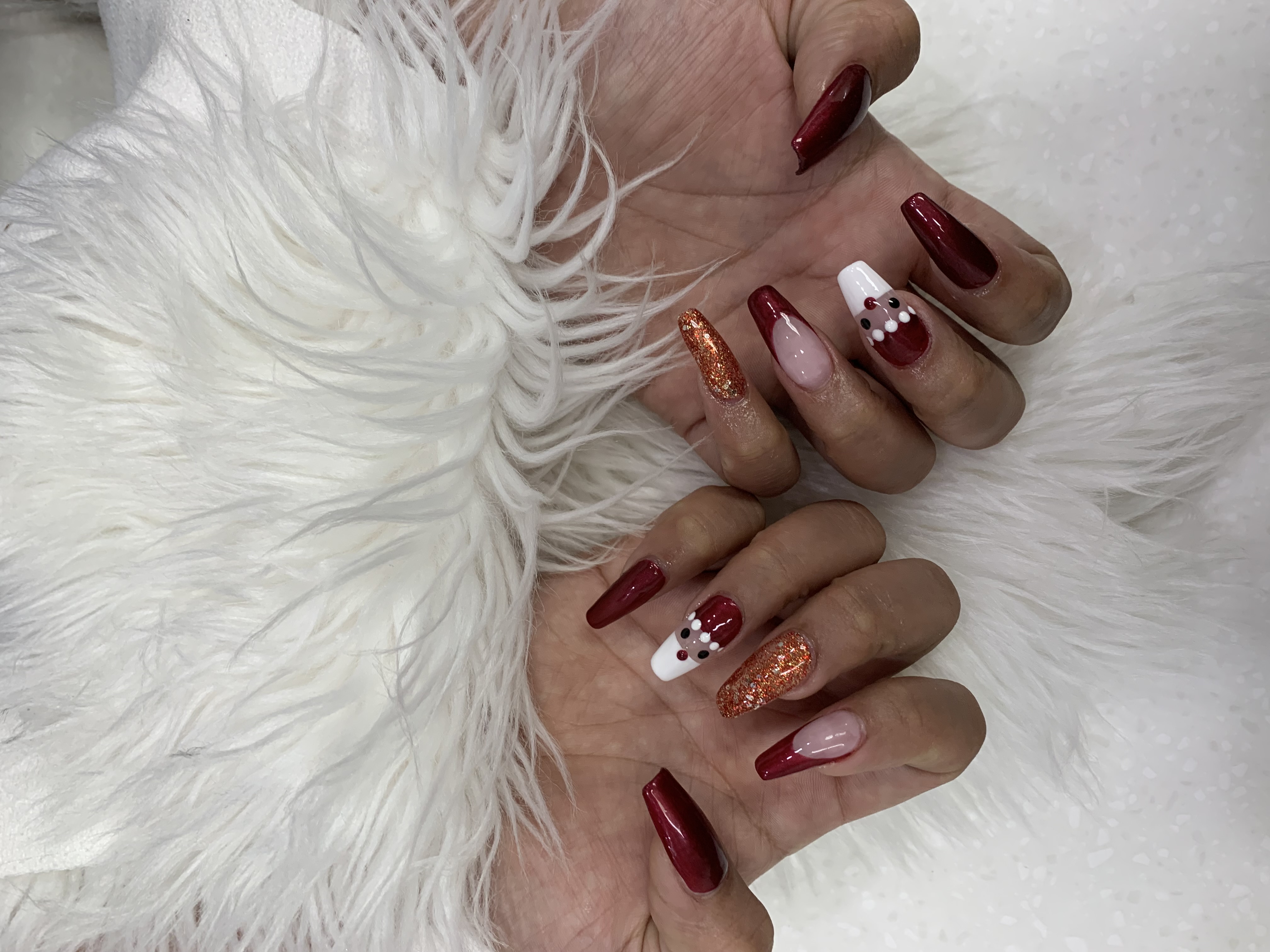 Red glitter nails with gem accents